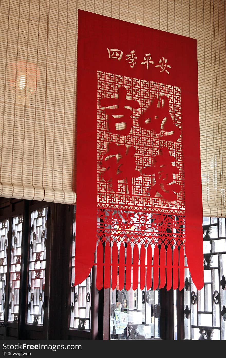 Ornamental paper-cut in the ancient room.

Chinese on the paper-cut is safe and having good luck.