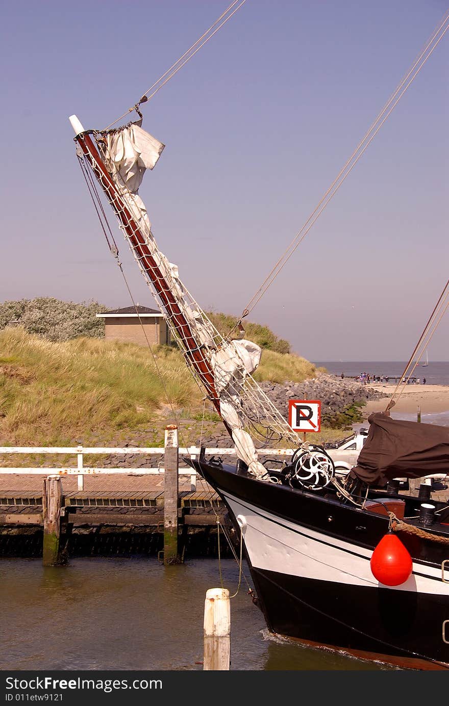 The bow of a  classic sailing ship in the entrance of a harbour