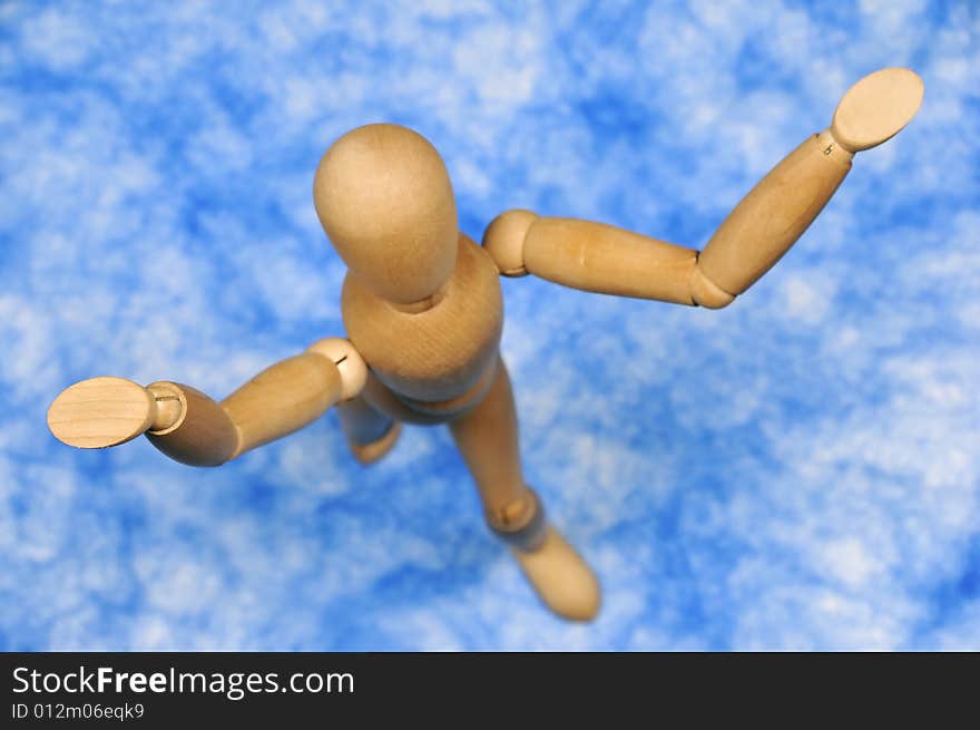 Standing wooden figurine against blue background