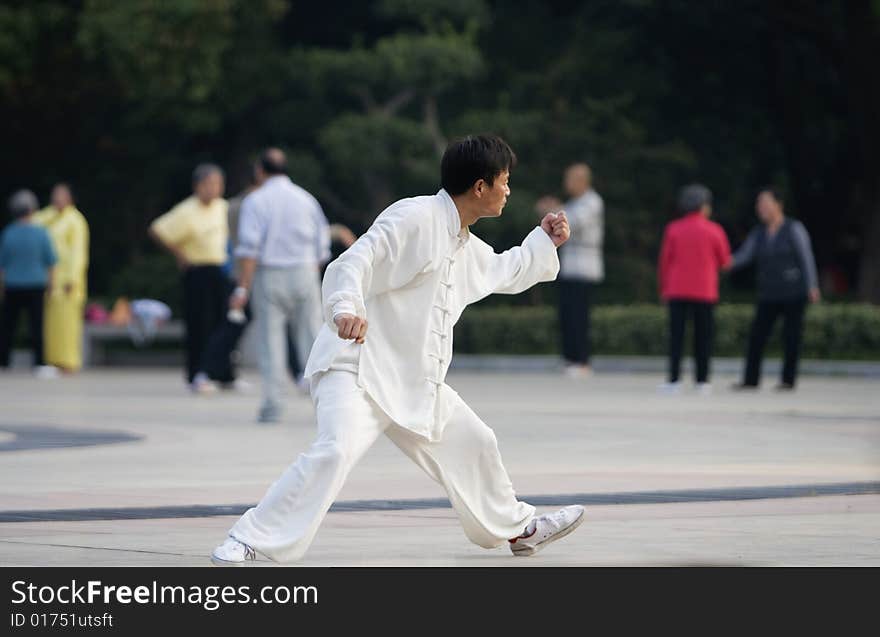 The man play the chinese wushu in a park morning. The man play the chinese wushu in a park morning.