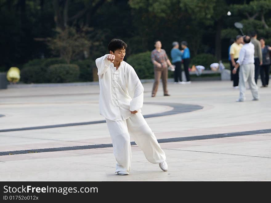 The man play the chinese wushu in a park morning. The man play the chinese wushu in a park morning.