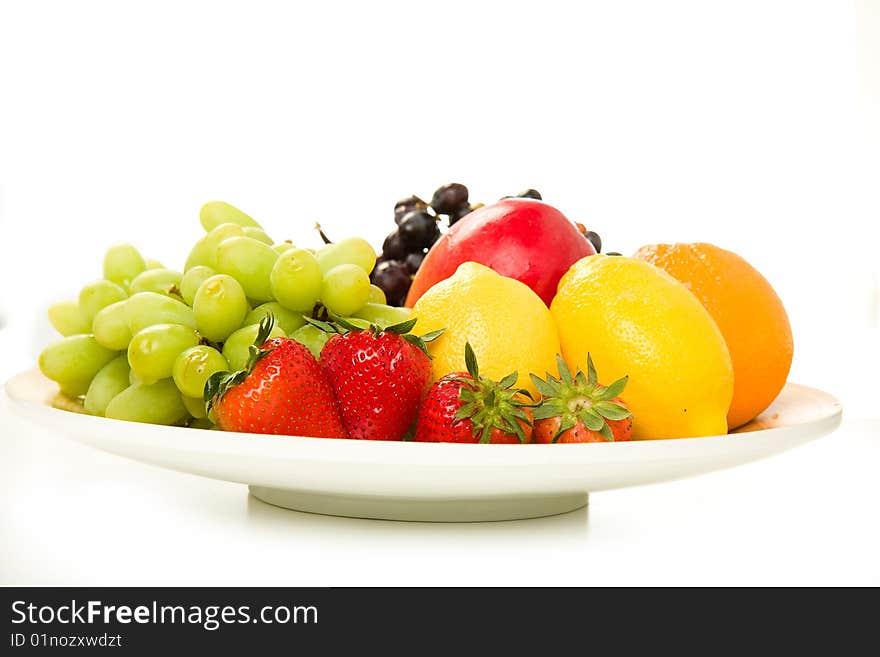 Fruit Platter with Red Grapes, Green Grapes, Mango, Lemon, Orange and Strawberry on white