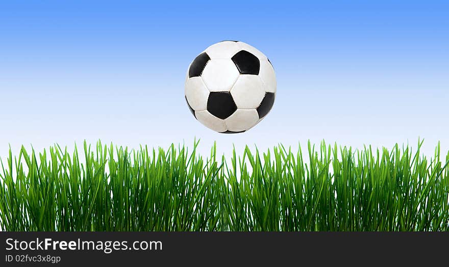 Soccer ball on the green field with grass