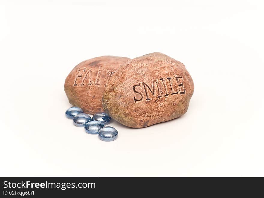 Inspirational Rocks Saying Smile and Faith with Colored Blue Stones on White.