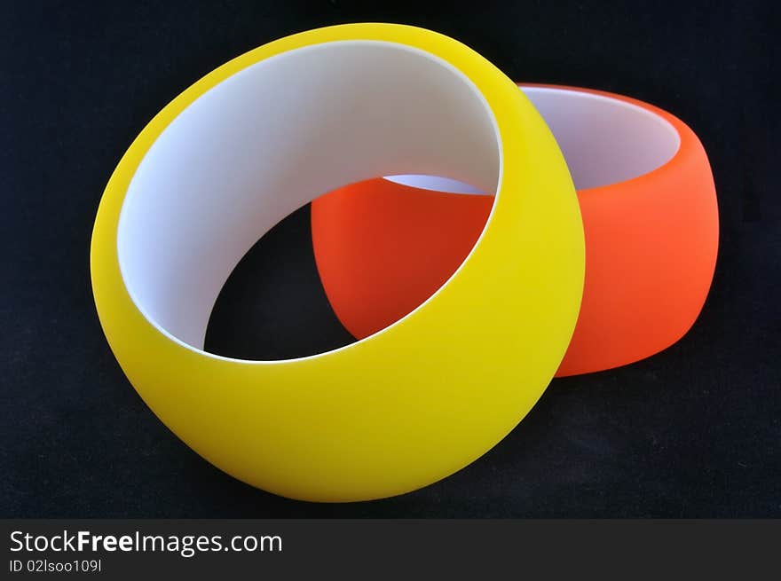 Yellow and orange polymer bracelets on black background. Yellow and orange polymer bracelets on black background