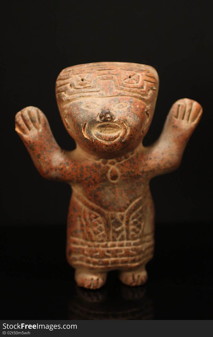 Photo of a Mexican terricotta figurine against a black background. Photo of a Mexican terricotta figurine against a black background.