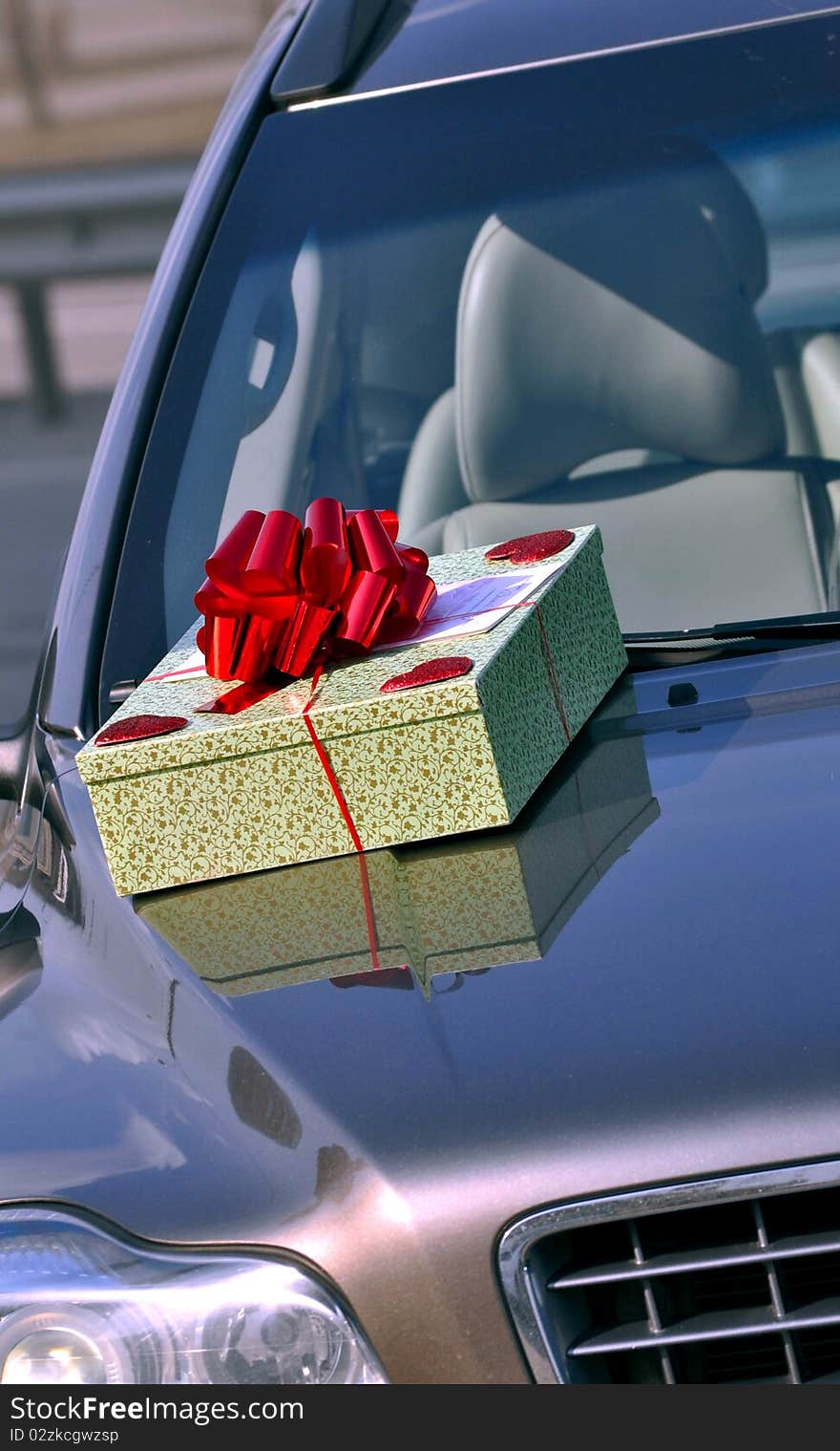 A present box on the car bonnet. A present box on the car bonnet