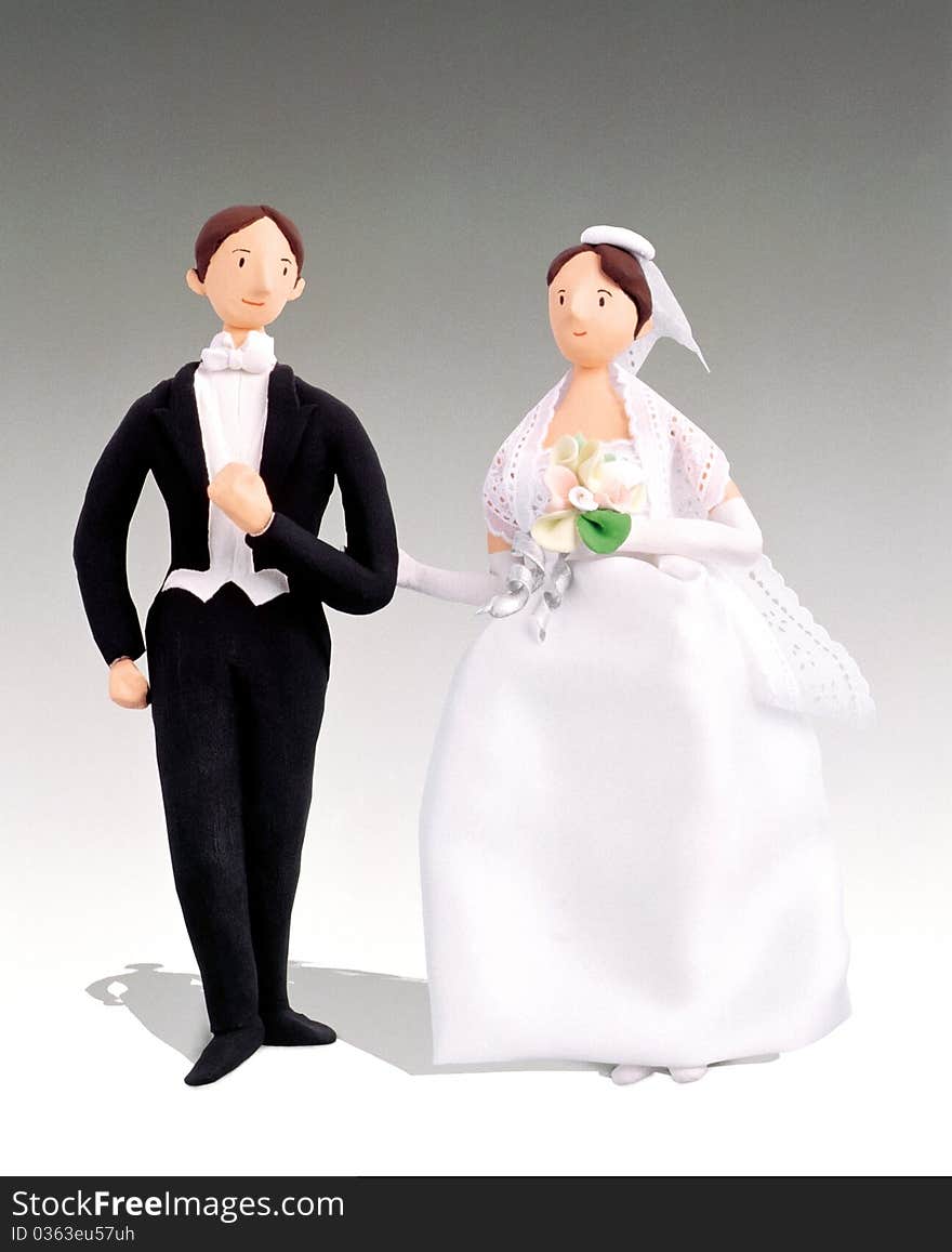 A pair of male and female figurines in wedding attire. A pair of male and female figurines in wedding attire.