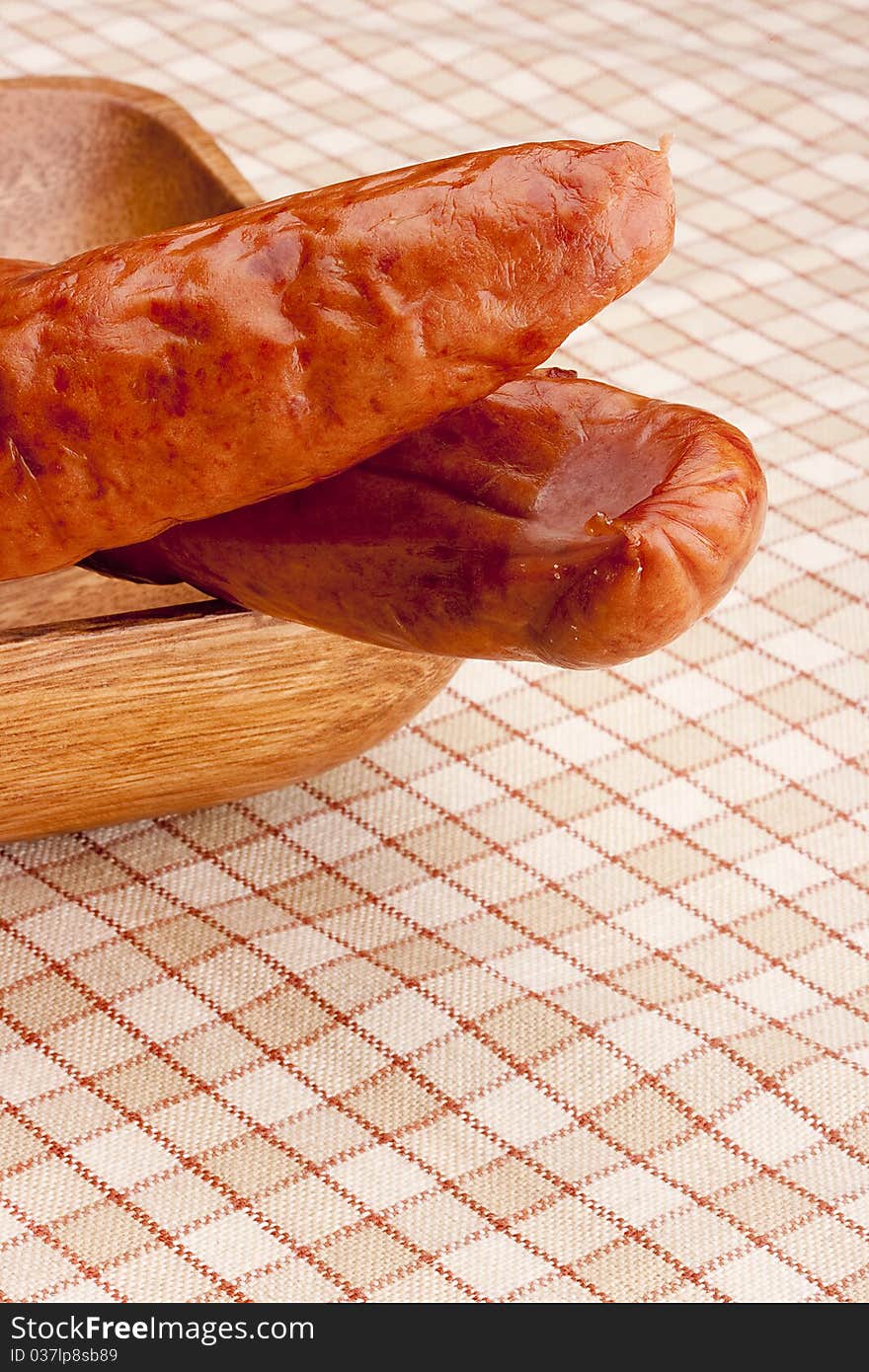 Smoked sausage on a background of cellular tissue.