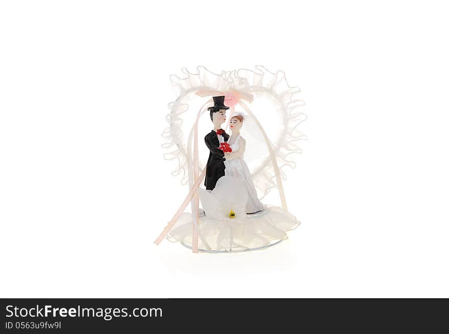 Wedding cake figurine of groom and bride with heart of white ribbon