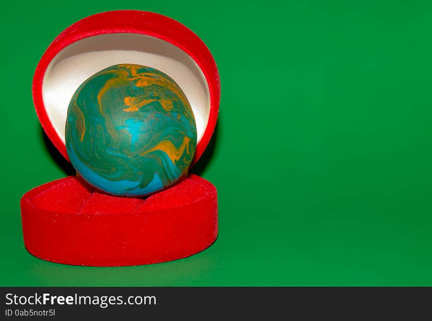 Earth style polymer clay ball in red jewelry box. Earth style polymer clay ball in red jewelry box