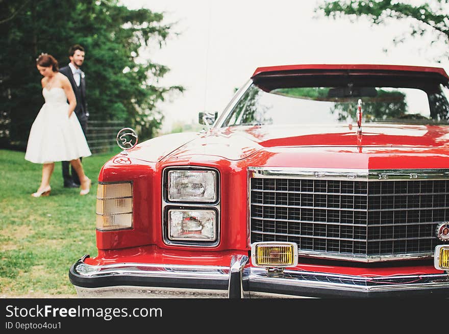 Couple Standing Near Red Classic Monte Carlo