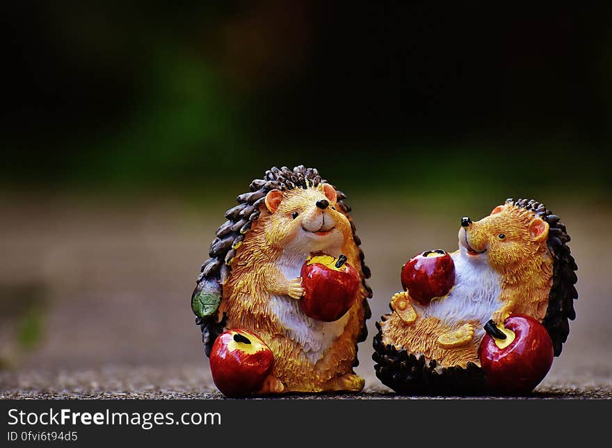 Close up of figurines of hedgehogs eating red apples. Close up of figurines of hedgehogs eating red apples.