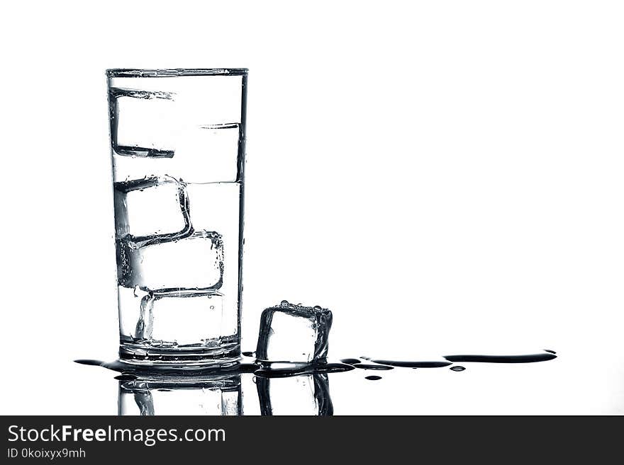 Ice cubes in fresh drinking water in glass on white background