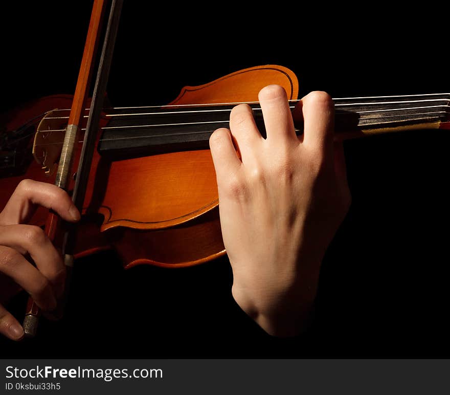 Violin and bow in hands of musician, isolated on black