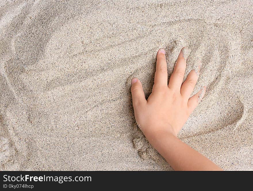 The child is playing with the sea sand. Relax, meditation