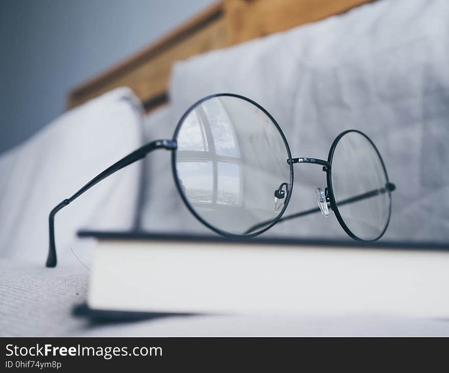 Eyeglasses and book in bedroom for reading and relax.