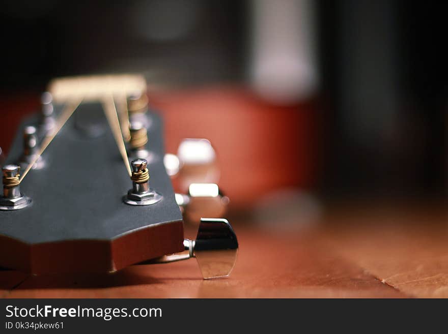 Macro of a professional Acoustic Guitar lying on a brown wooden table