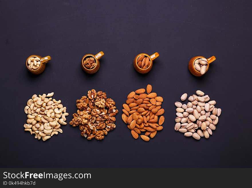 Assortment of nuts on a black background - healthy snack.