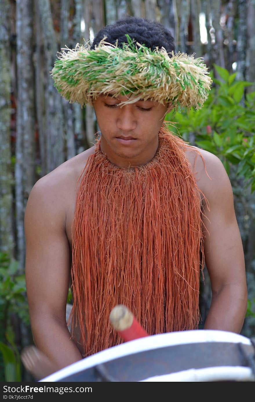 Cook Islander man plays music on a large drum instrument in Rarotonga Cook Islands