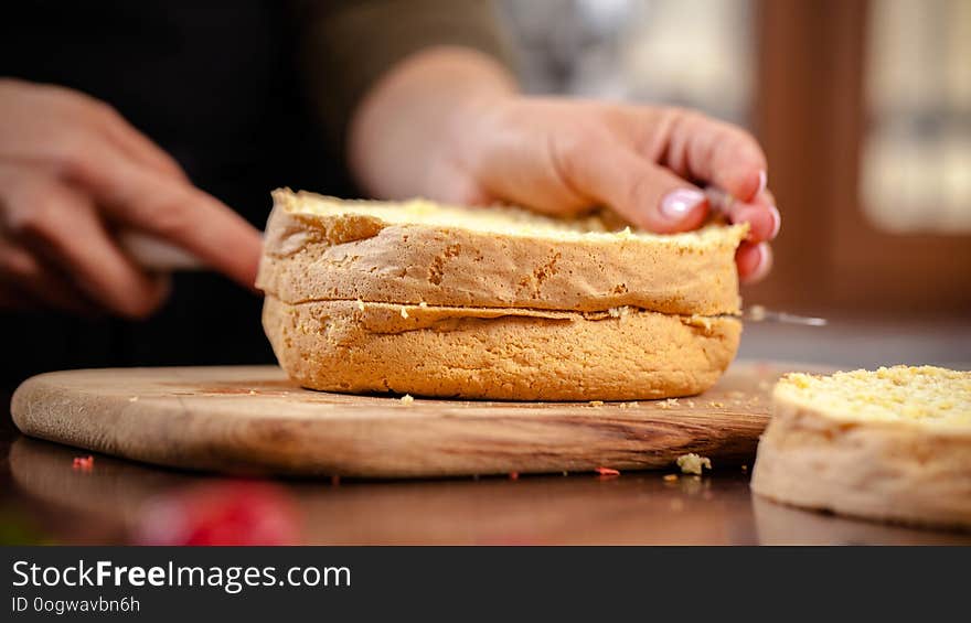 The pastry chef prepares a biscuit cake in the home kitchen or in a restaurant. The concept of the process of making cakes for restaurants, cafes and bars. on the photo the girl hands cuts a biscuit. The pastry chef prepares a biscuit cake in the home kitchen or in a restaurant. The concept of the process of making cakes for restaurants, cafes and bars. on the photo the girl hands cuts a biscuit