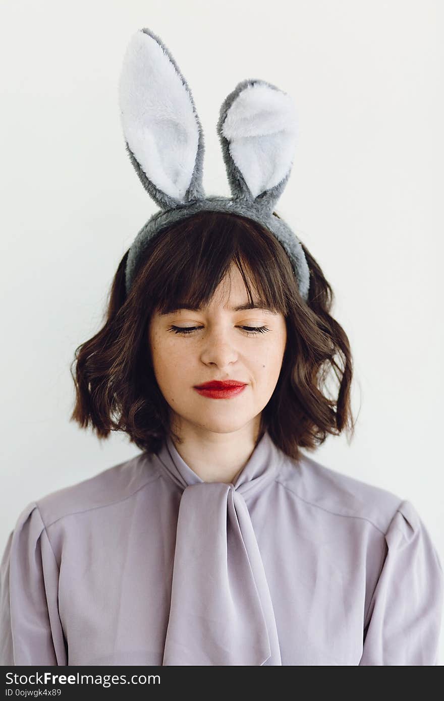 Beautiful young woman in bunny ears calm portrait on white background indoors, space for text. Easter hunt concept. Happy Easter greetings