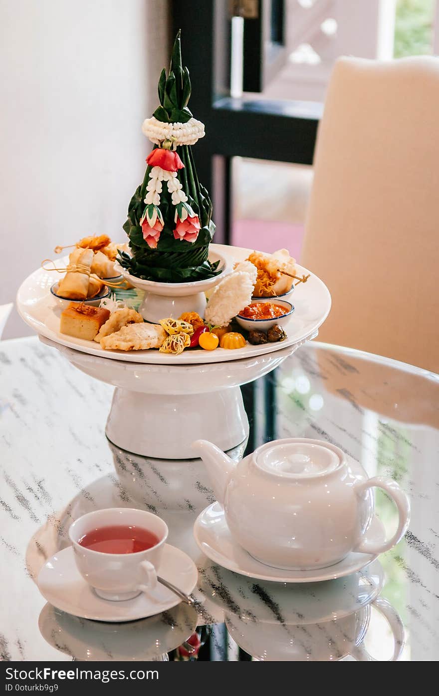 Thai assorted traditional dessert snack on ceramic pedestal tray with tea set