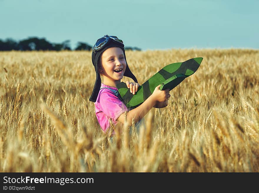 Cheerful girl in a field with wheat model aircraft. Cheerful girl in a field with wheat model aircraft