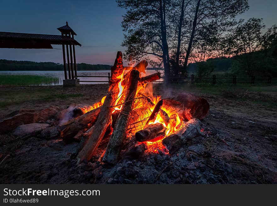 Calm bonfire at dusk by the lake in summer, Europe