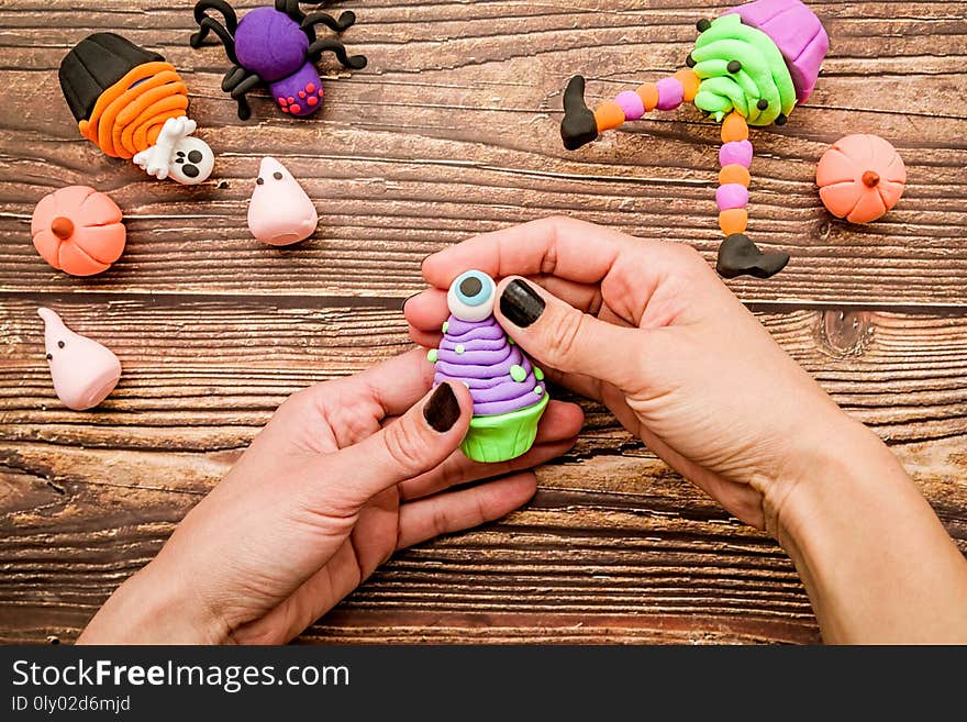 Halloween concept. female hands with black nails making halloween cupcake craft top view. Halloween concept. female hands with black nails making halloween cupcake craft top view