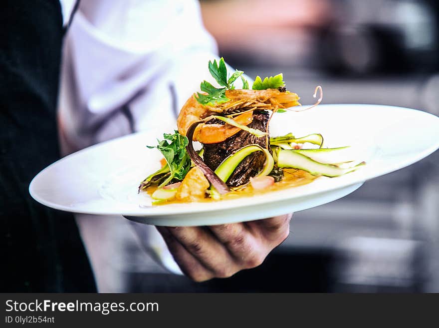 Modern food stylist decorating meal for presentation in restaurant. Closeup of food stylish. Restaurant serving