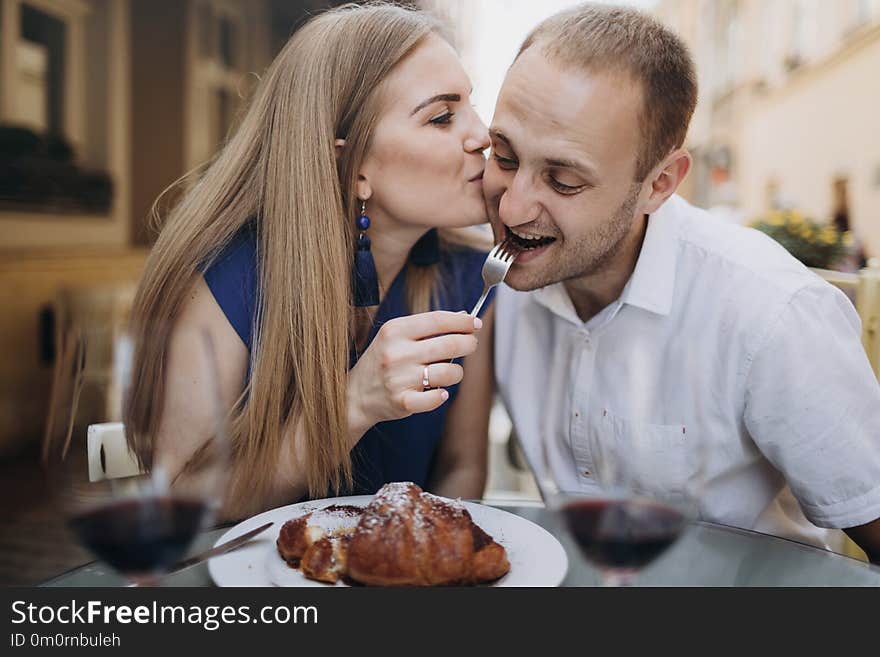 Cheerful couple in a restaurant with glasses of red wine. Young couple with glasses of red wine in a restaurant .