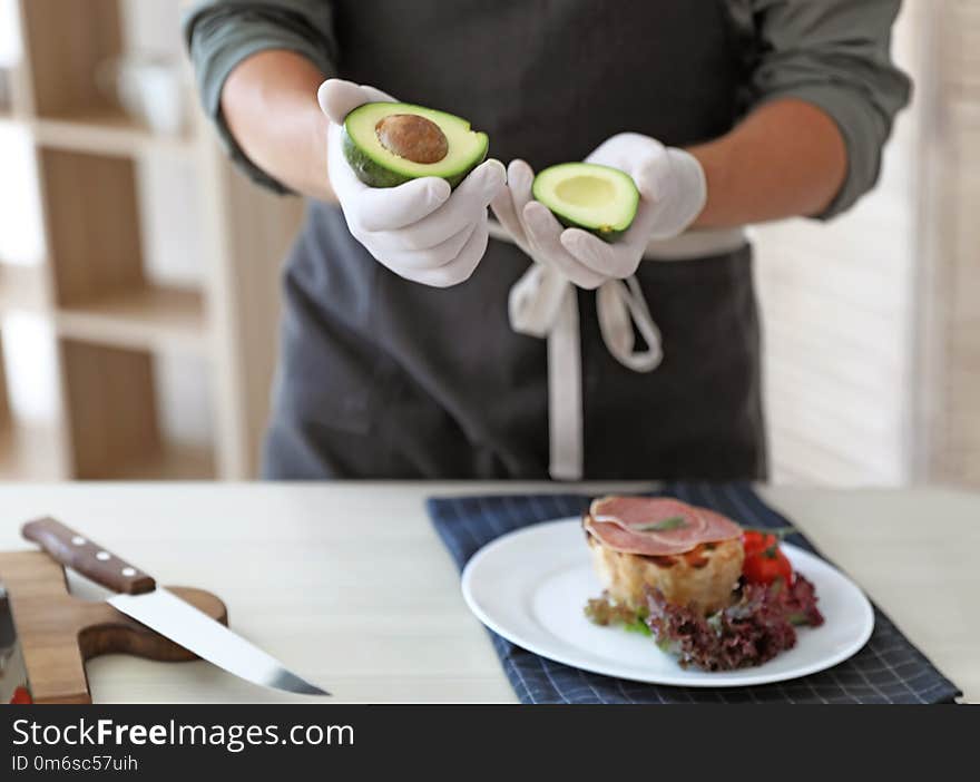 Professional chef preparing dish on table in kitchen, closeup