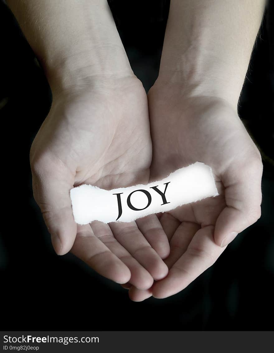 Hands holding joy word sign on paper illustrating choosing to be happy. Hands holding joy word sign on paper illustrating choosing to be happy