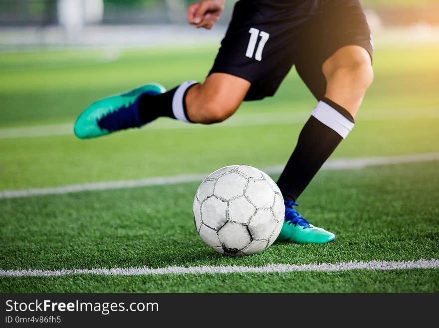 Soccer player speed run to shoot ball to goal on artificial turf. Soccer player training or football match.