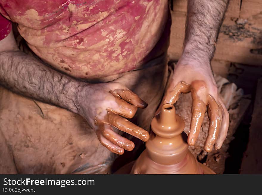 Professional potter making bowl in pottery workshop, studio.