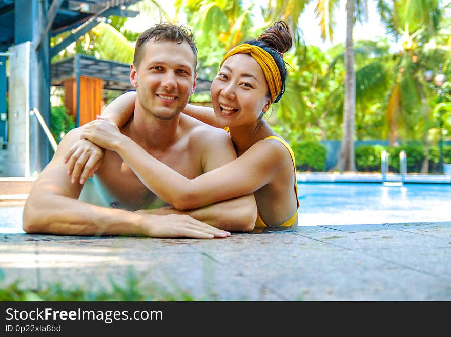 Beautiful photo of happy couple in the pool chatting with each other.