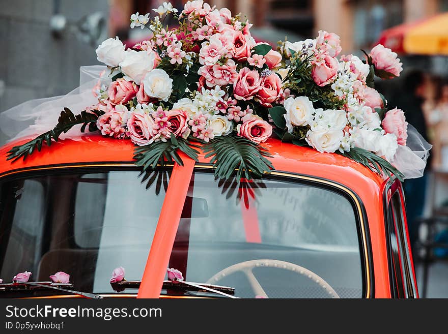 Old red car with red ribbon and flowers on top. Old red car with red ribbon and flowers on top