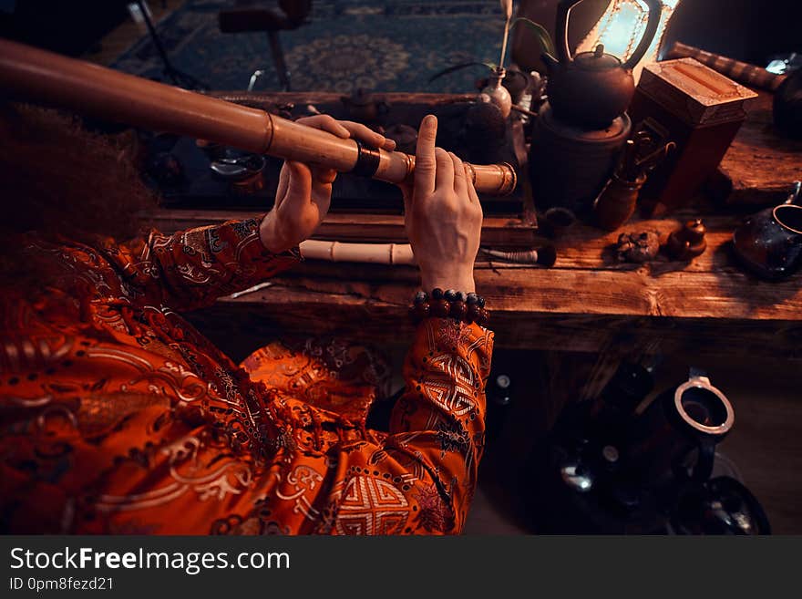 Tradition, health, harmony. Chinese tea ceremony. Tea master in kimono performs in the dark room with a wooden interior