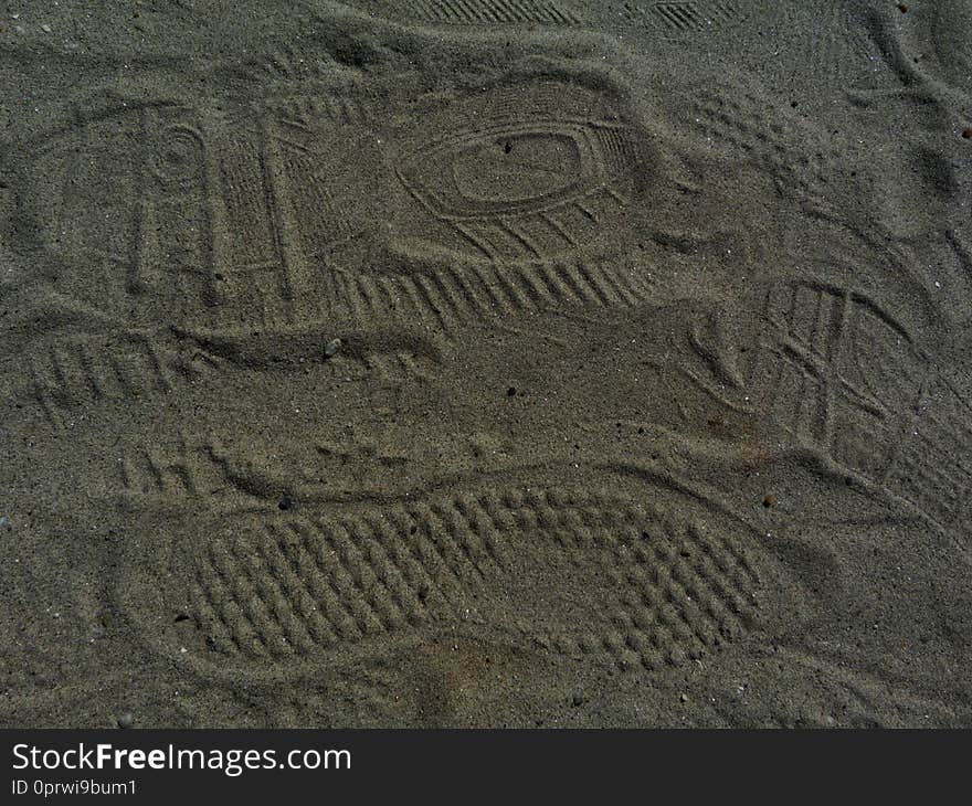 Shoe print abstract in fine grey sand. foot print patterns left in sand. background image.