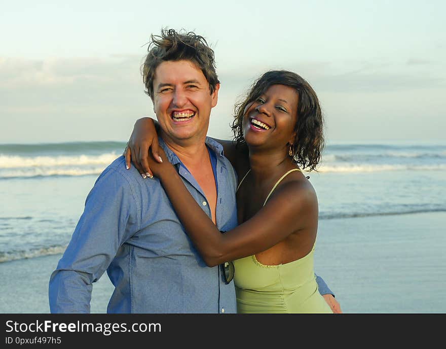 Happy and beautiful mixed ethnicity couple with beautiful afro American woman and cheerful Caucasian man enjoying holidays