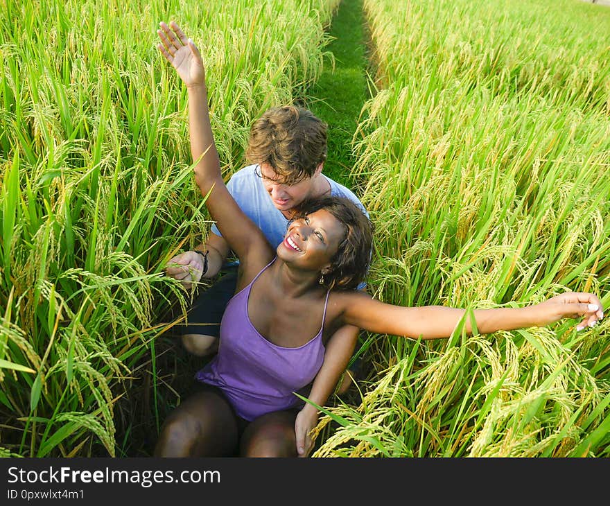 Young happy and beautiful mixed ethnicity couple with black African American woman and attractive Caucasian man cuddling and