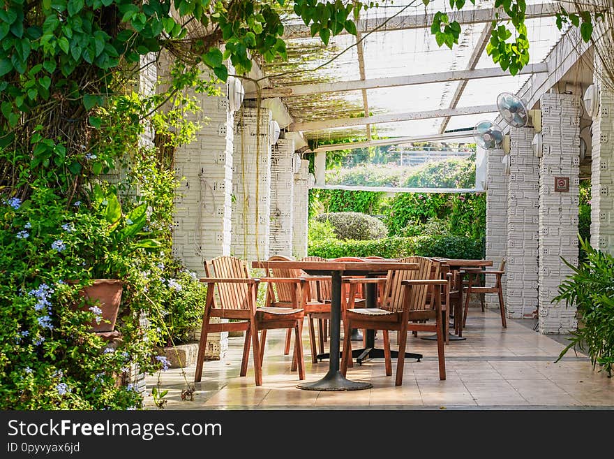 Open air restaurant atmosphere with electric fans and no smoking sign on post