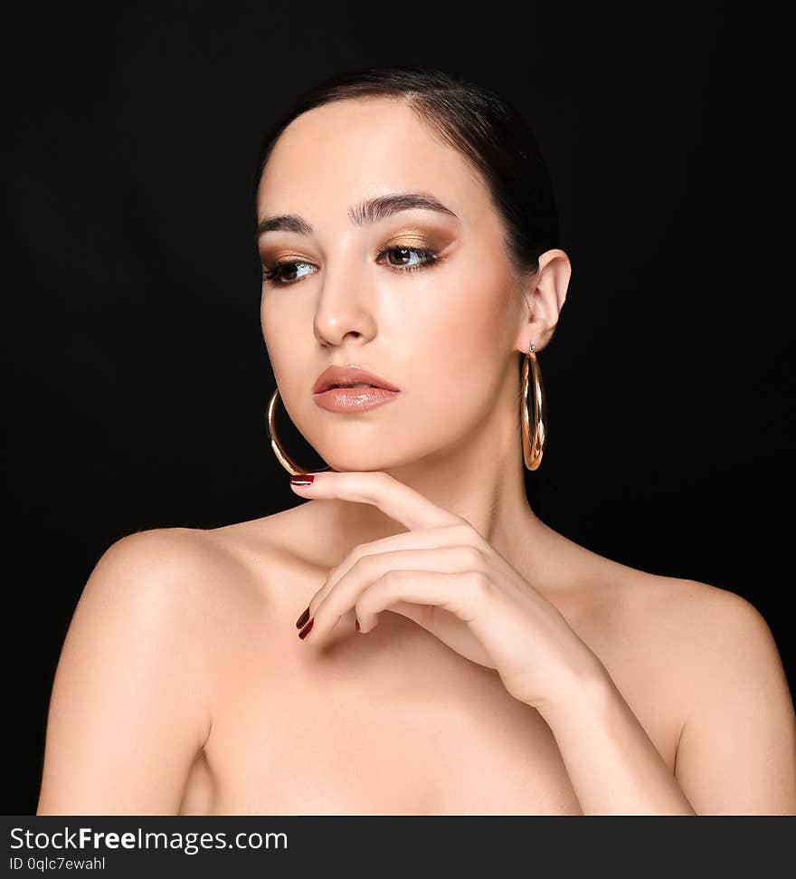 Portrait of young woman with beautiful professional makeup on black background