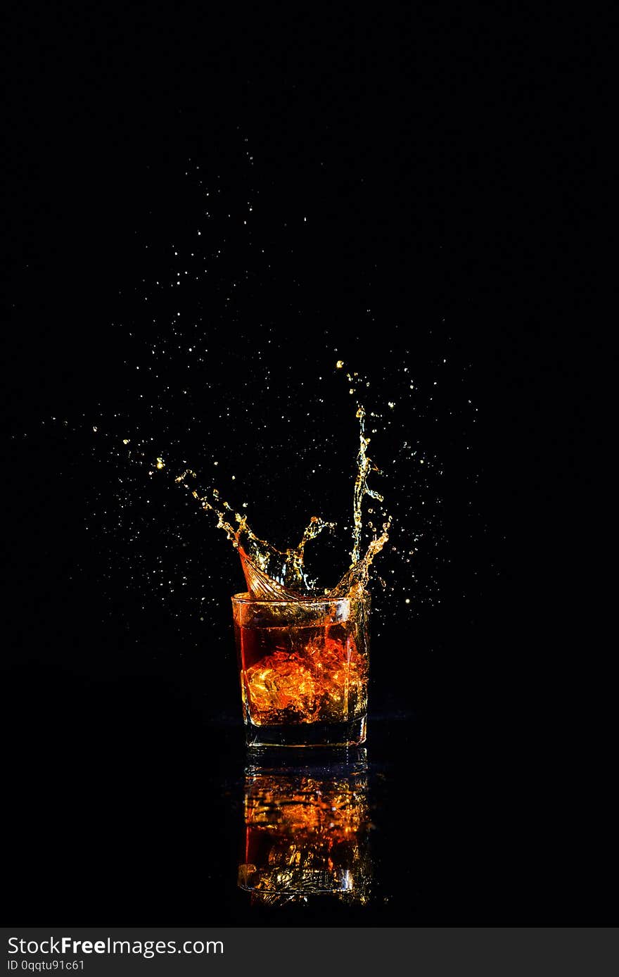 whiskey with splash on black background, brandy in a glass