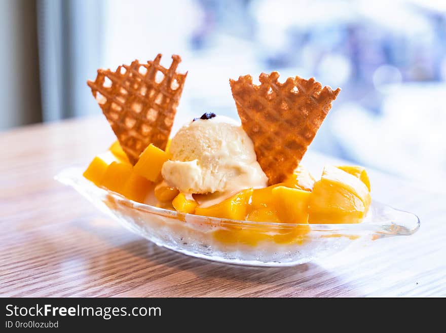 Fresh mango shaved ice with a scoop of ice cream and juice sauce in summer restaurant, lifestyle, popular food in Taiwan, close up.