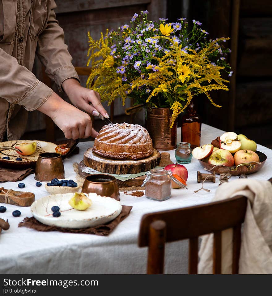 Beautiful outdoor still life in country garden with bundt cake on wooden stand on rustic table