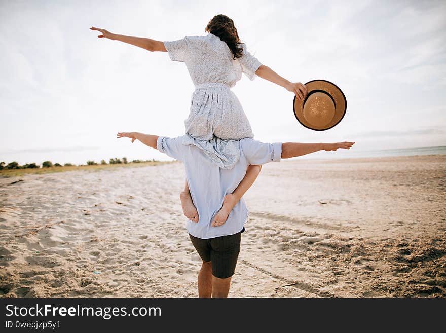 Honeymoon on a desert island. Happy young couple walking on the beach. The concept of freedom