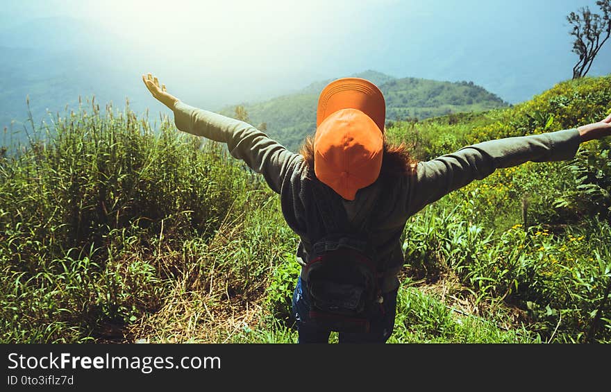 Asian woman travel relax in the holiday.  Stand and watch landscape on the Moutain. Mountain park happily. In Thailand