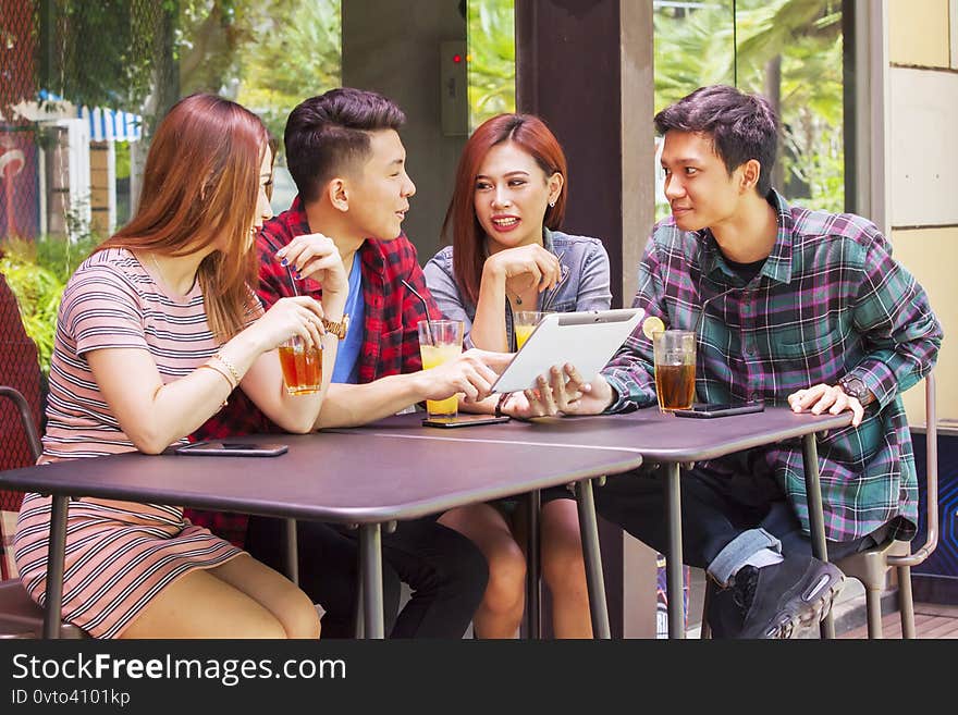 Portrait of young people using digital tablet while spending leisure time in restaurant. Portrait of young people using digital tablet while spending leisure time in restaurant